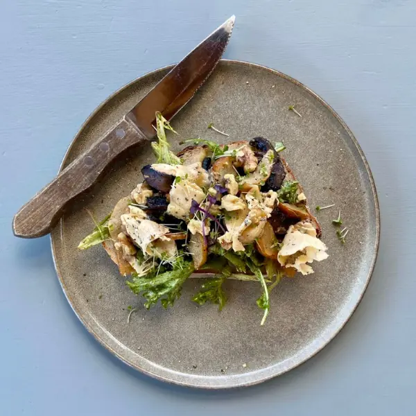 Rustic open sandwich with mushrooms, chicken, greens, and shaved cheese, served on sourdough at Volcanoview café, Taranaki.